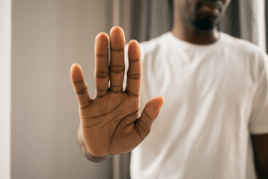 mans hand showing stop sign - certificate of good standing denial