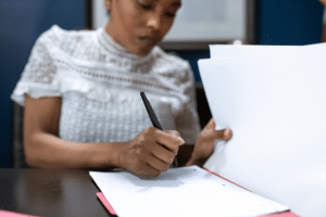 how to convert sole proprietorship to an llc - woman signing papers to make her llc official